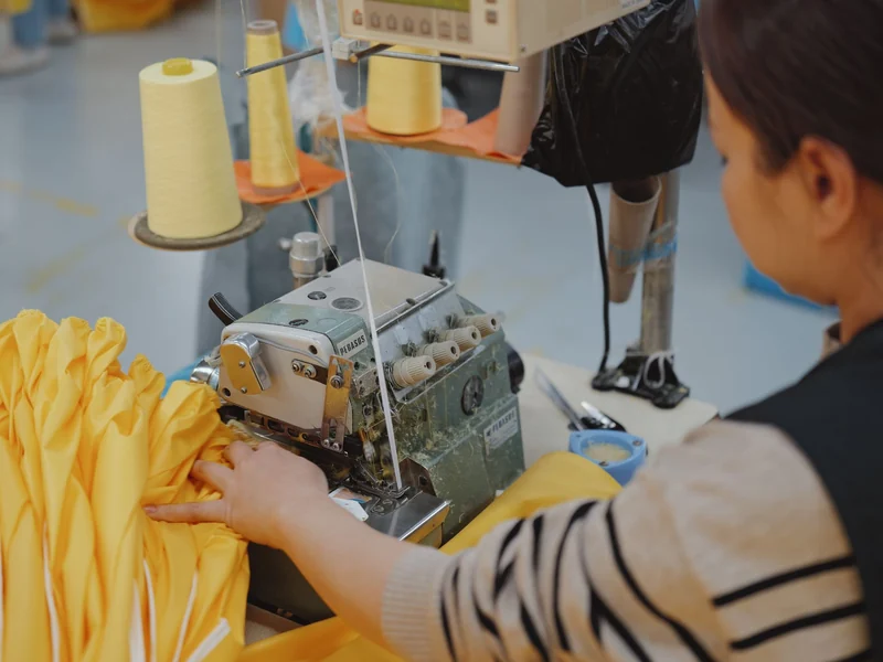 Sewing operator finishing seams on an industrial overlock machine