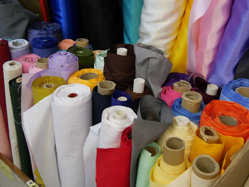 Rolls of satin and shell fabrics in many colours for bomber jacket production
