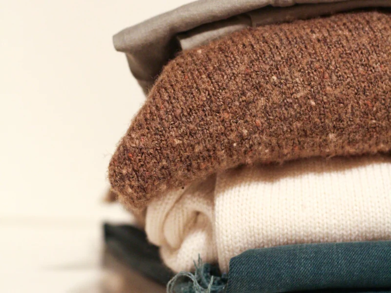 Small stack of folded wool and knit garments from a small batch production run